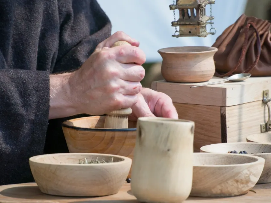 Hands grinding natural ingredients with a mortar and pestle