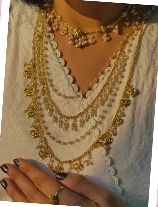 Legacy by Bisma layered gold necklaces over a white kurta